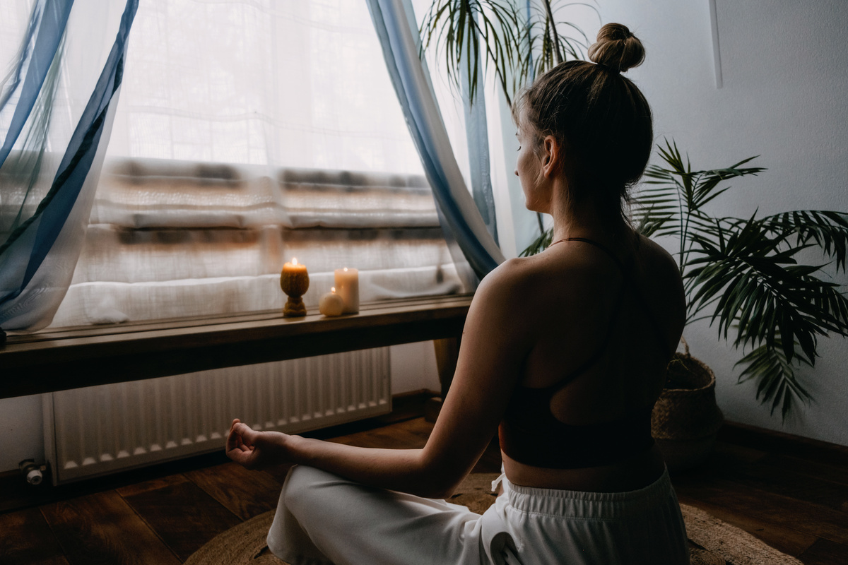 Mulher sentada em posição de meditação, uma das técnicas utilizadas na filosofia Ho'oponopono.