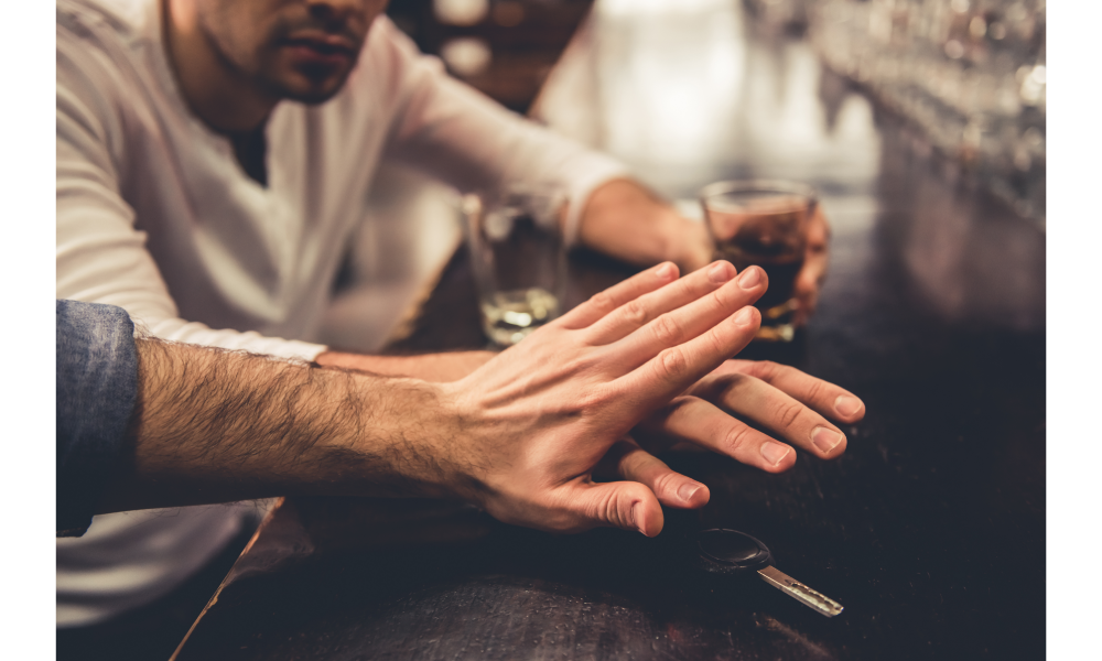 Amigo impedindo o outro a pegar a chave de um carro em um bar.