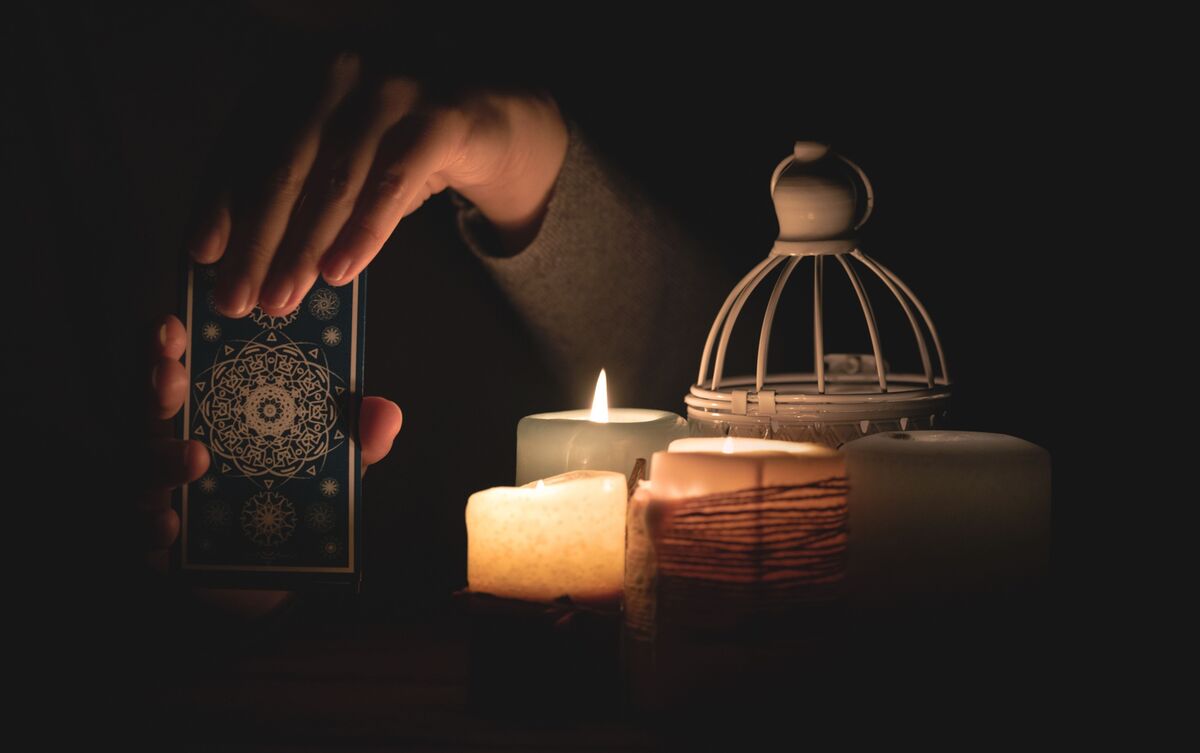 Tarólogo segurando cartas de Tarot.