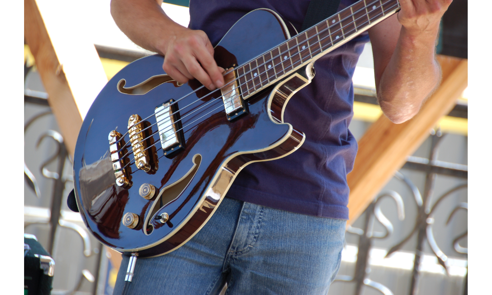 Homem tocando uma guitarra preta.