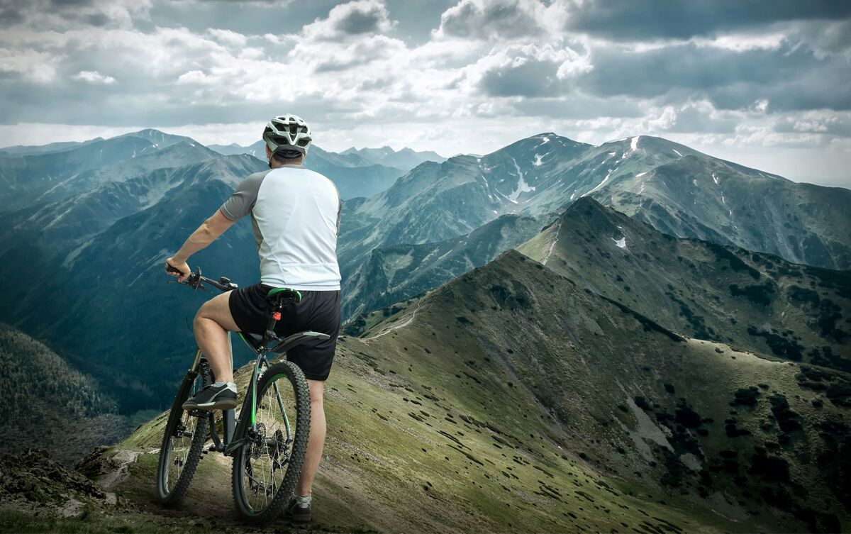 Homem andando de bicicleta ao ar livre.