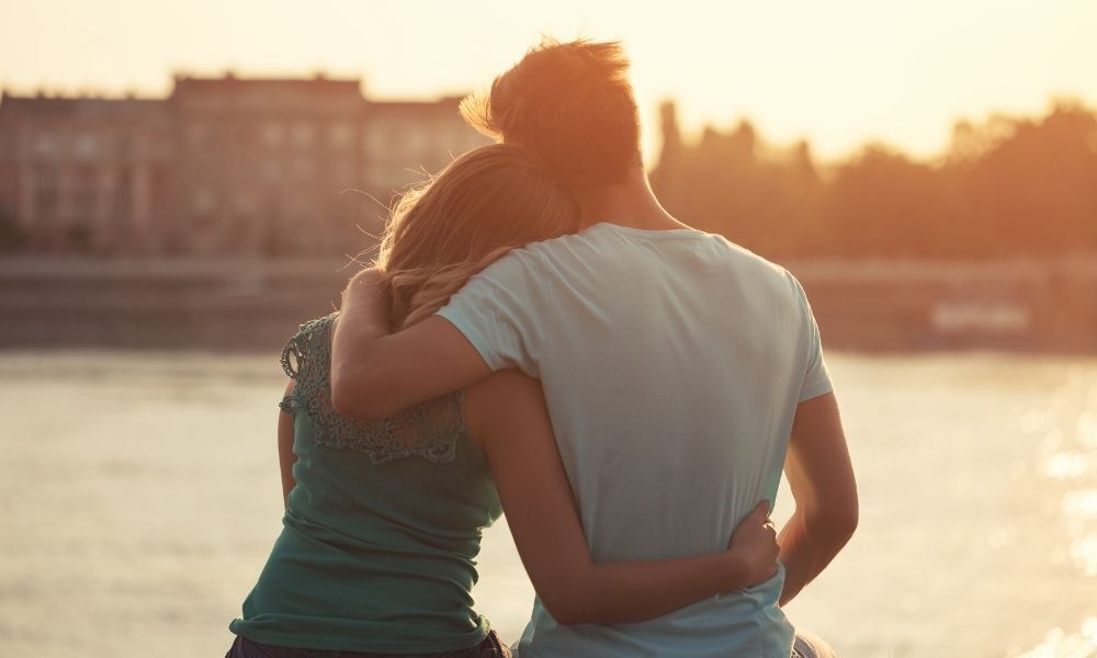 Casal de homem e mulher abraçados.