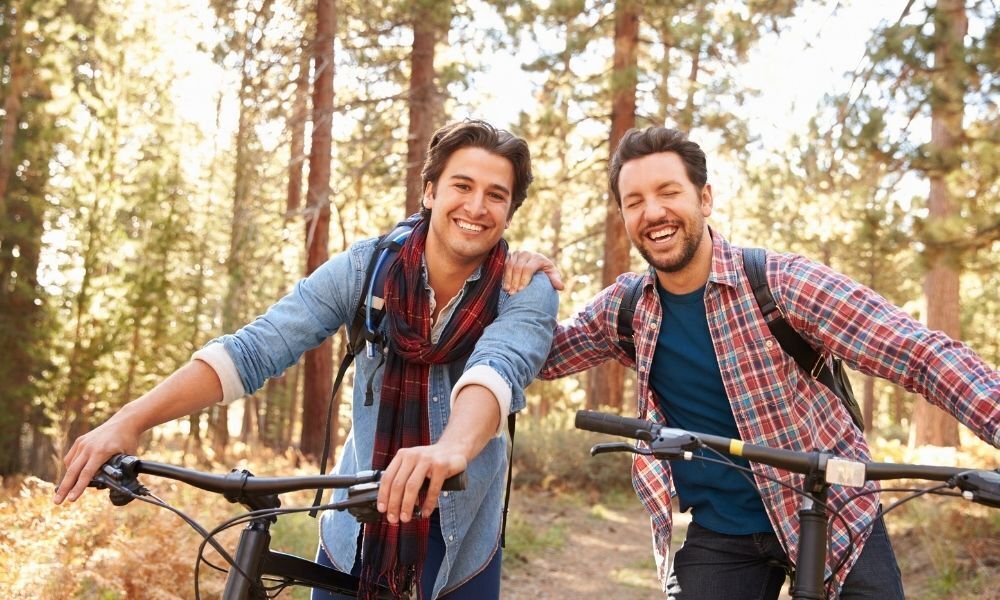 Casal de homens andando de bicicleta.