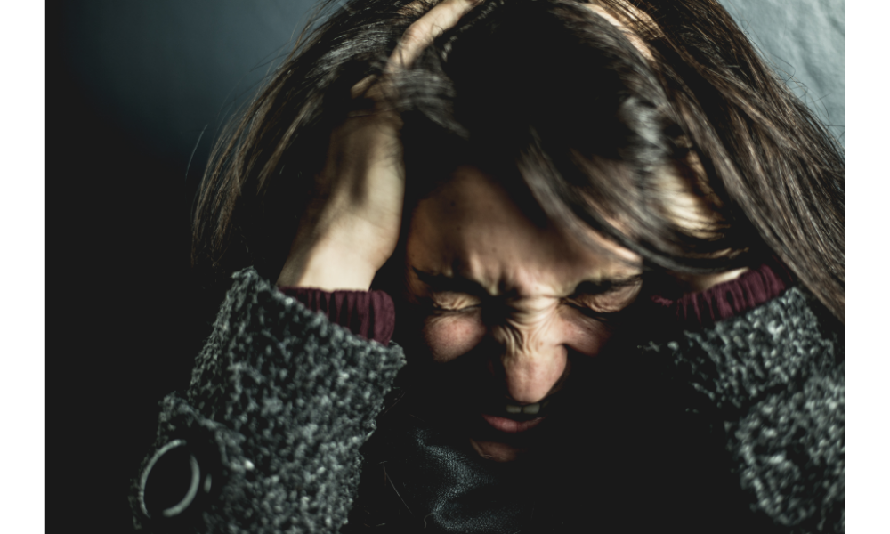 Mulher estressada com as mãos na cabeça.