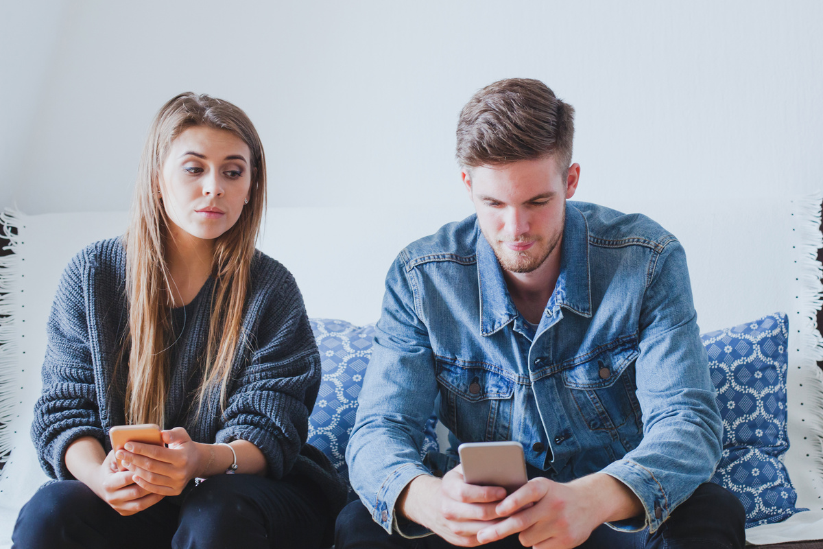 Mulher com ciúmes do namorado no celular