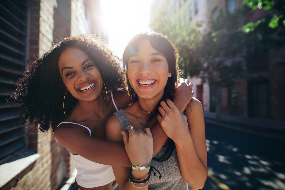 Amigas se abraçando e sorrindo