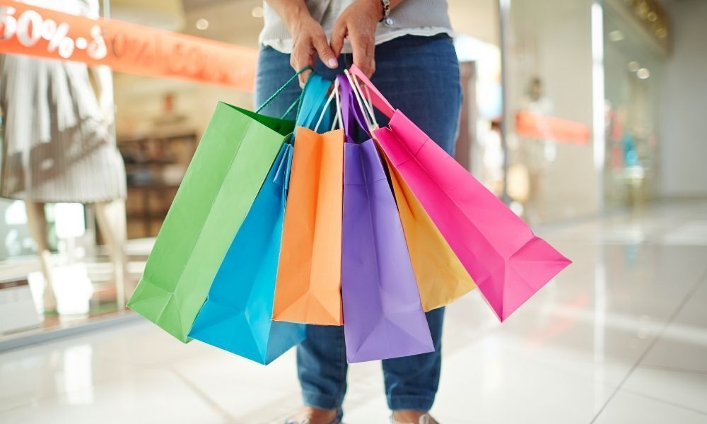 Pessoa segurando sacolas de compras.