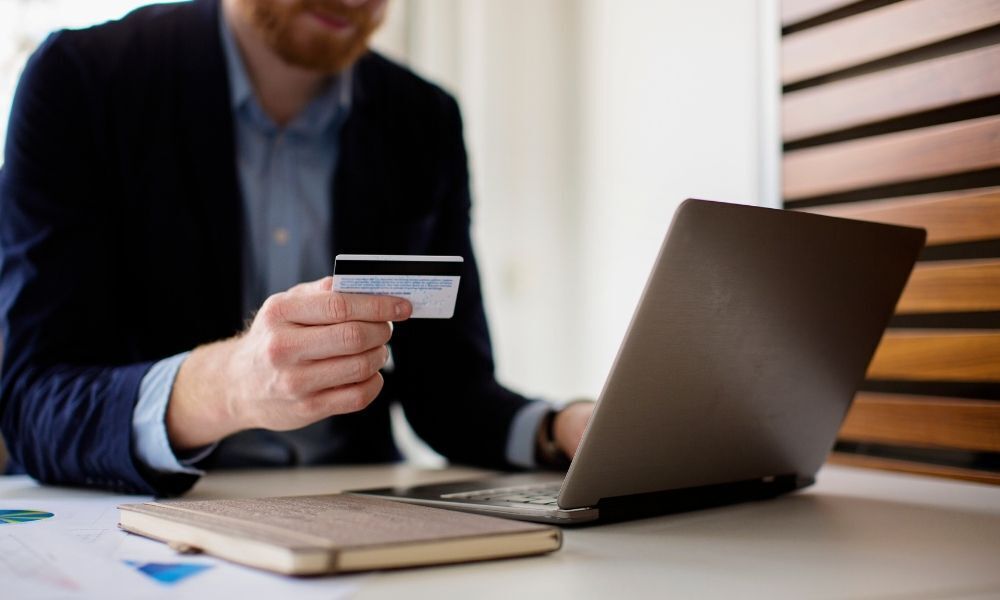 Homem fazendo compras com cartão de crédito na internet.