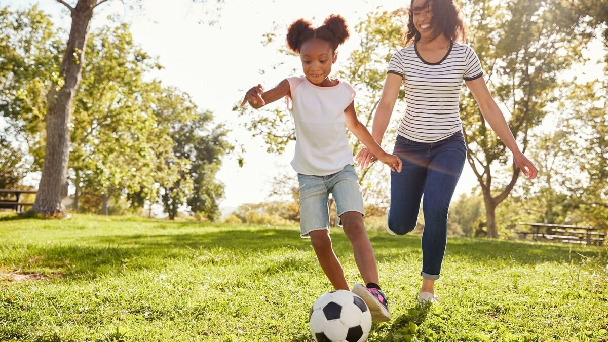 Mãe e filha jogando bola.