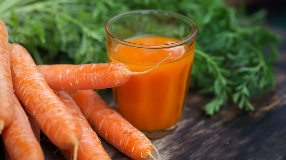 Copo com suco de cenoura.