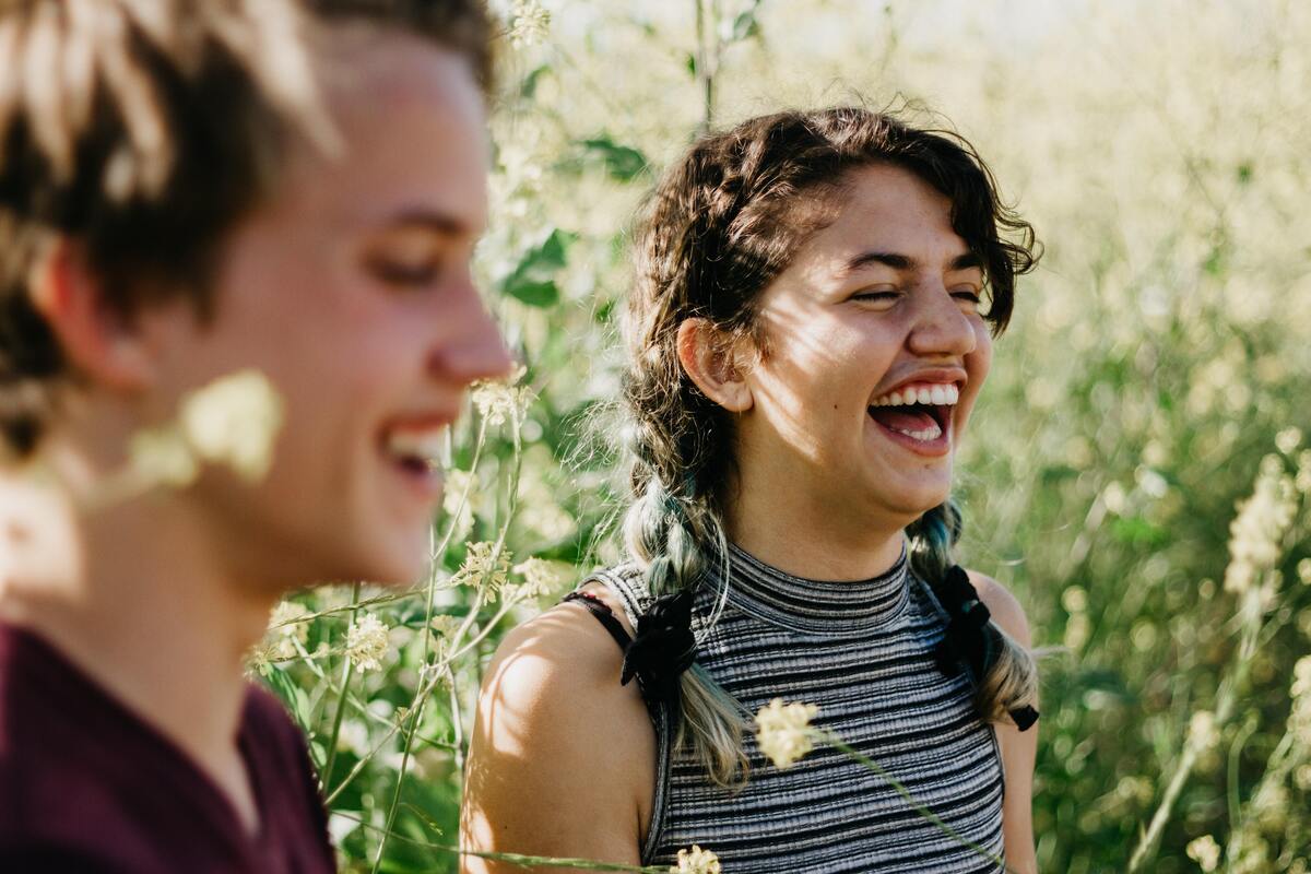 Casal rindo junto no campo.