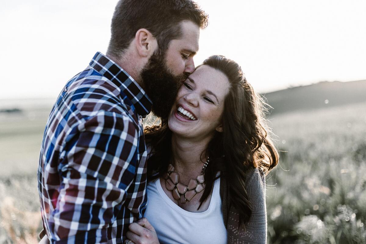 Casal abraçado em um campo.