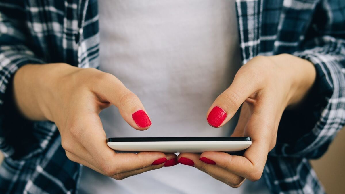 Mulher digitando no celular.