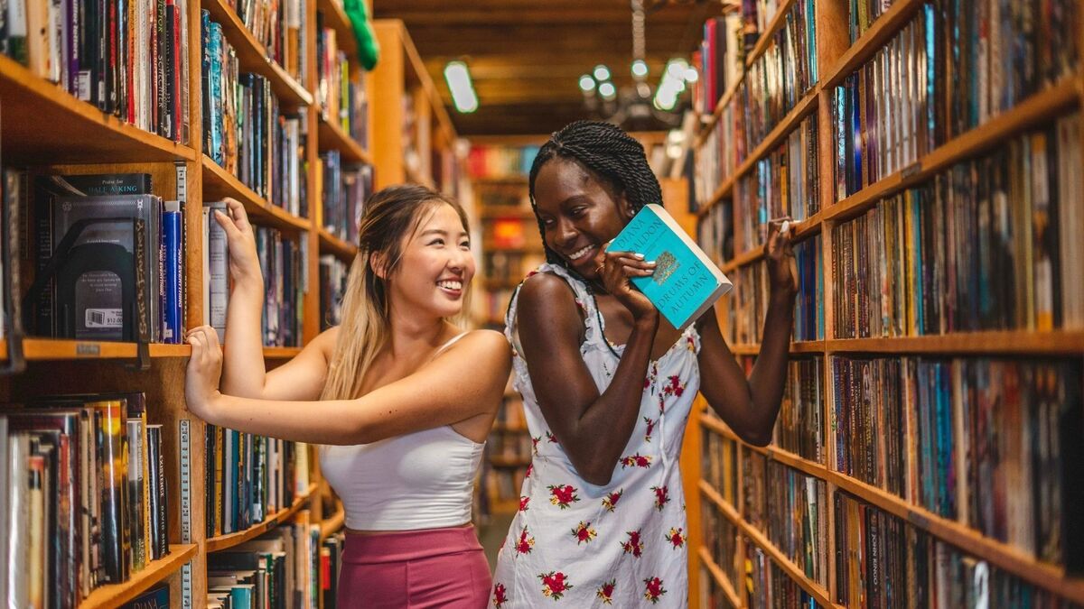 Duas amigas em uma biblioteca.