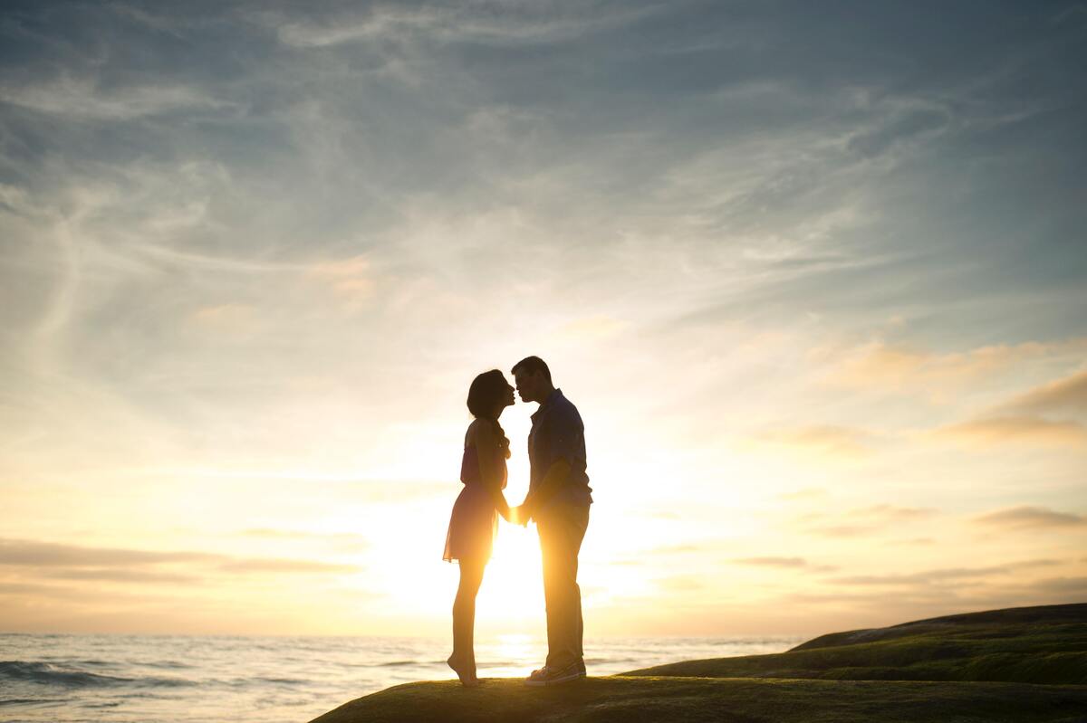 Casal se beijando em cima de uma pedra.