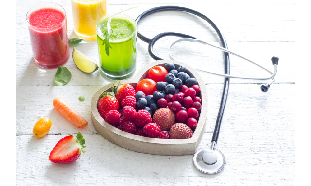 Pote em formato de coração com frutas, ao lado de um estetoscópio.