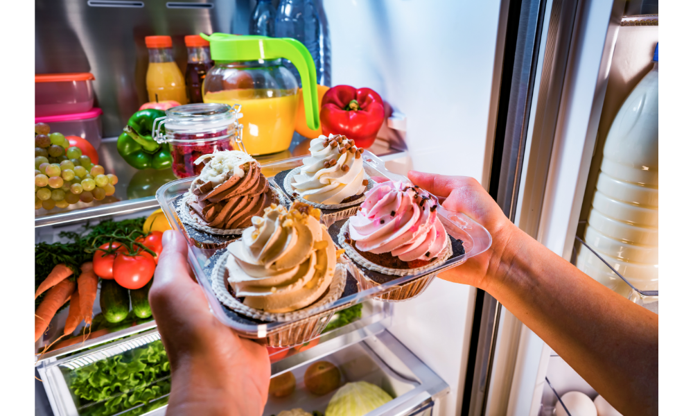 Pessoa colocando cupcakes em uma geladeira.