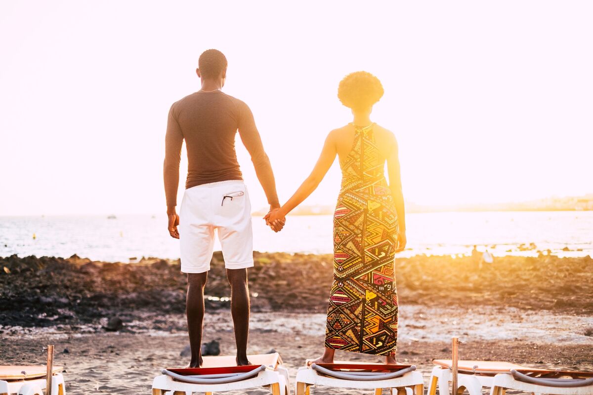 Casal de homem e mulher dando as mãos.