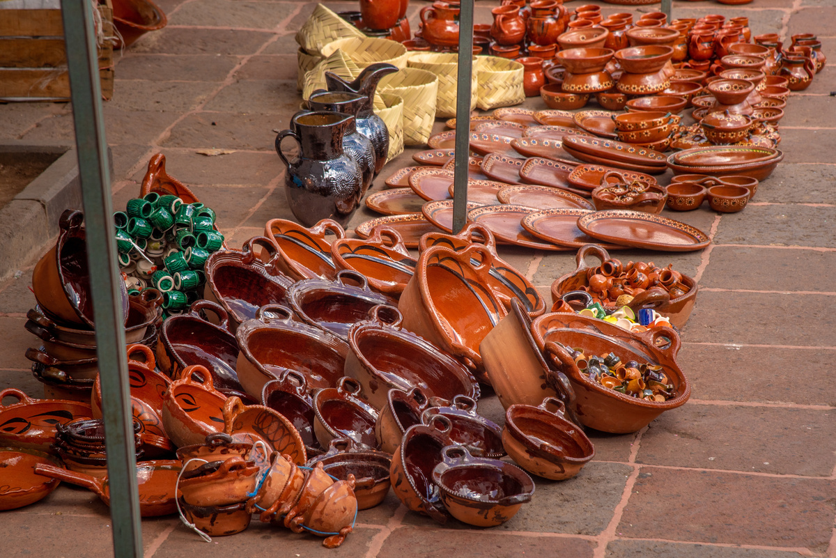 Utensílios de barro na calçada de uma rua