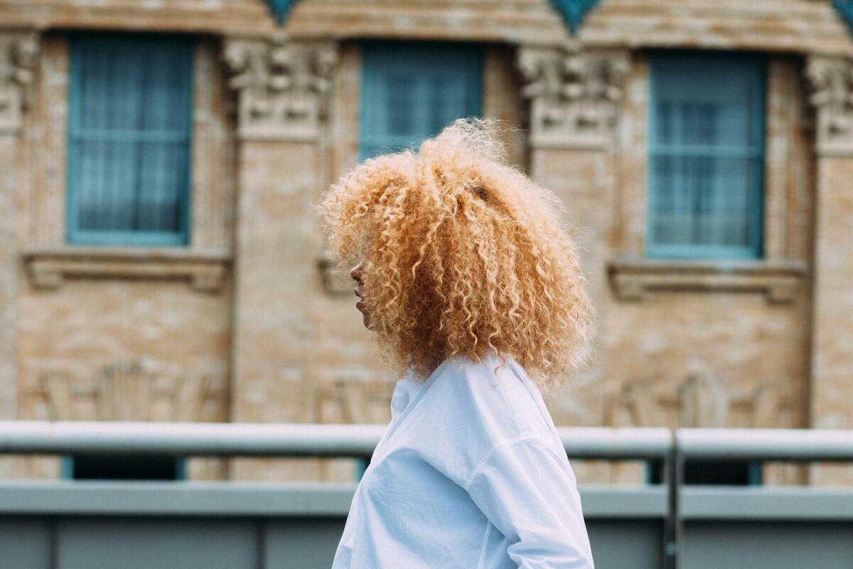 Mulher de cabelo loiro de costas.