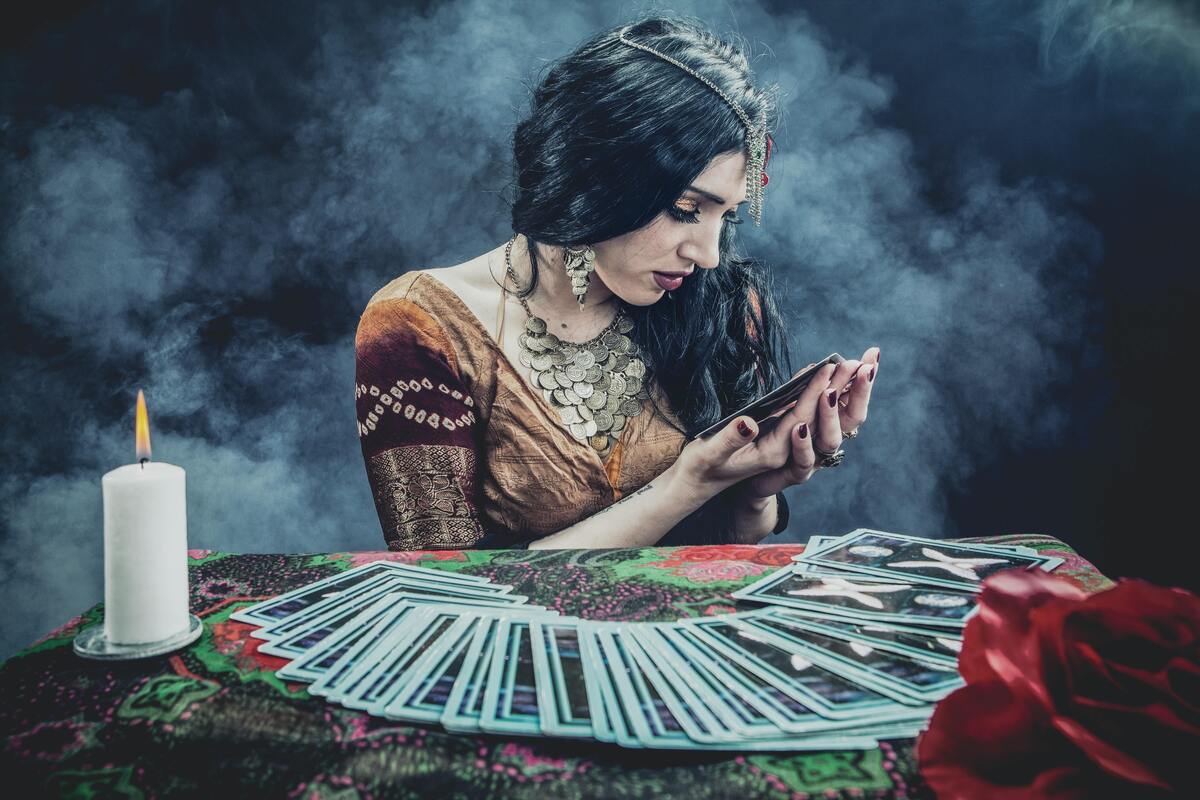 Mulher estudando baralho de tarot.