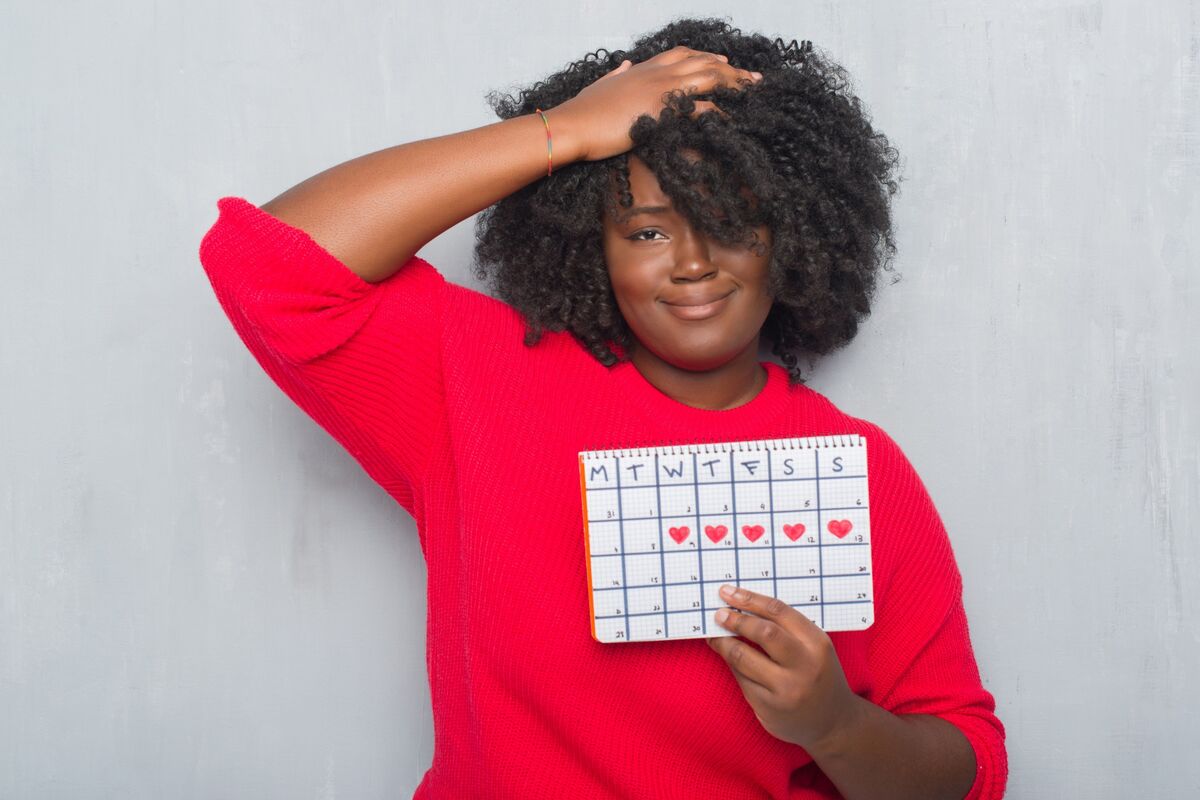 Mulher segurando calendário menstrual.