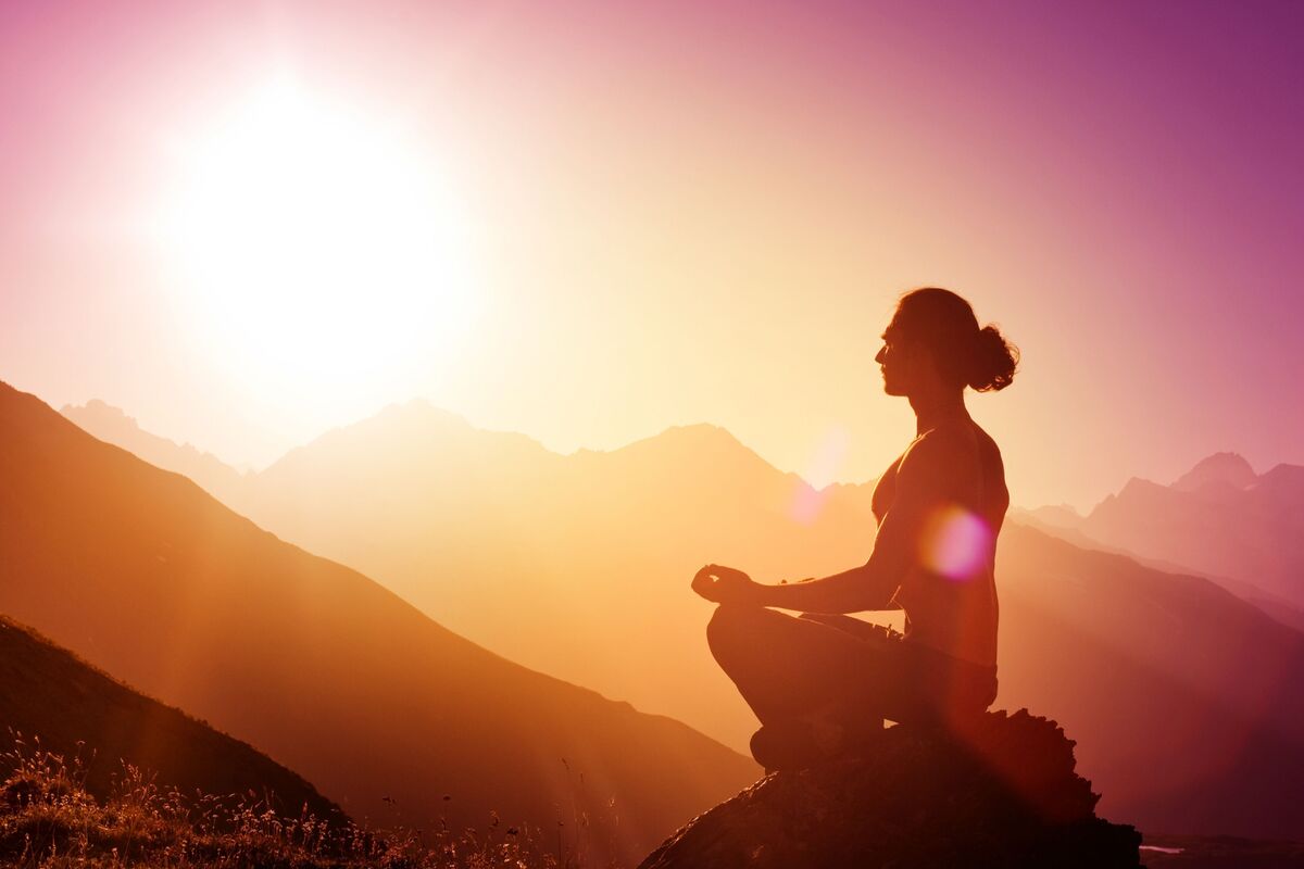 Mulher meditando em rochas.