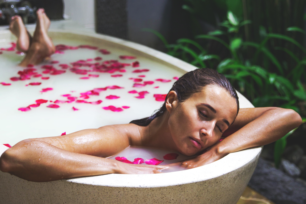 Mulher tomando banho de rosas.