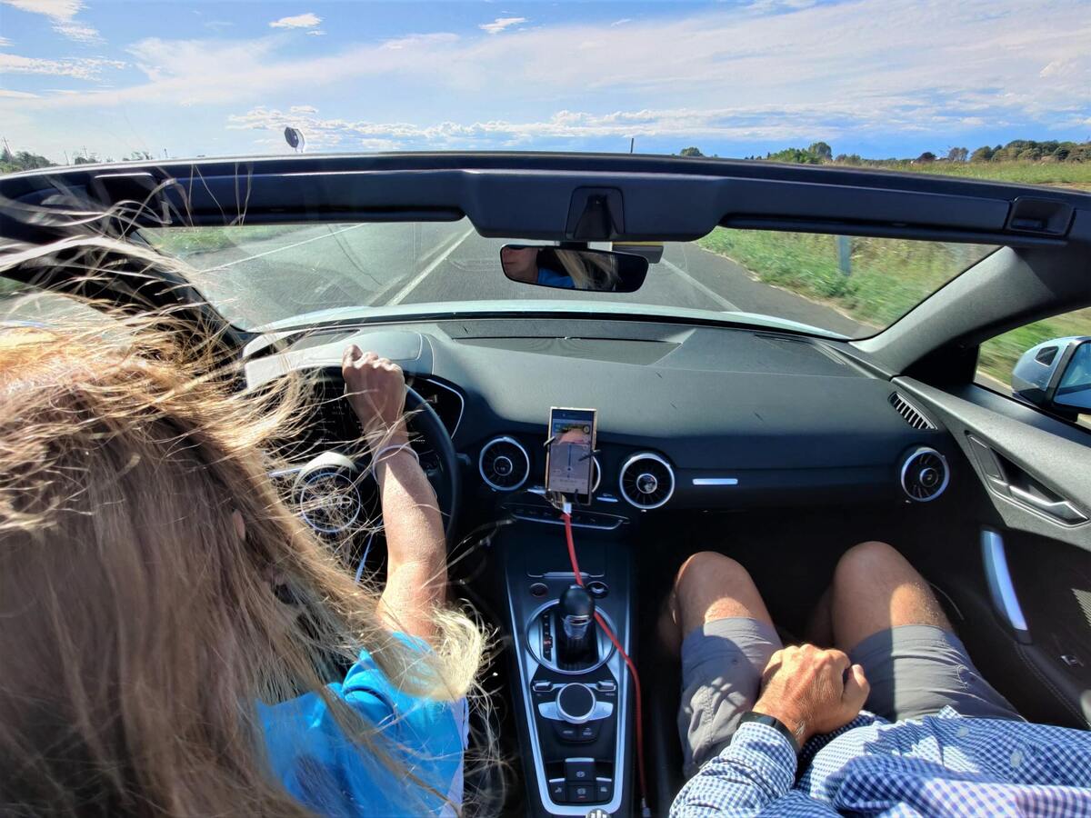 Mulher dirigindo carro conversível. 