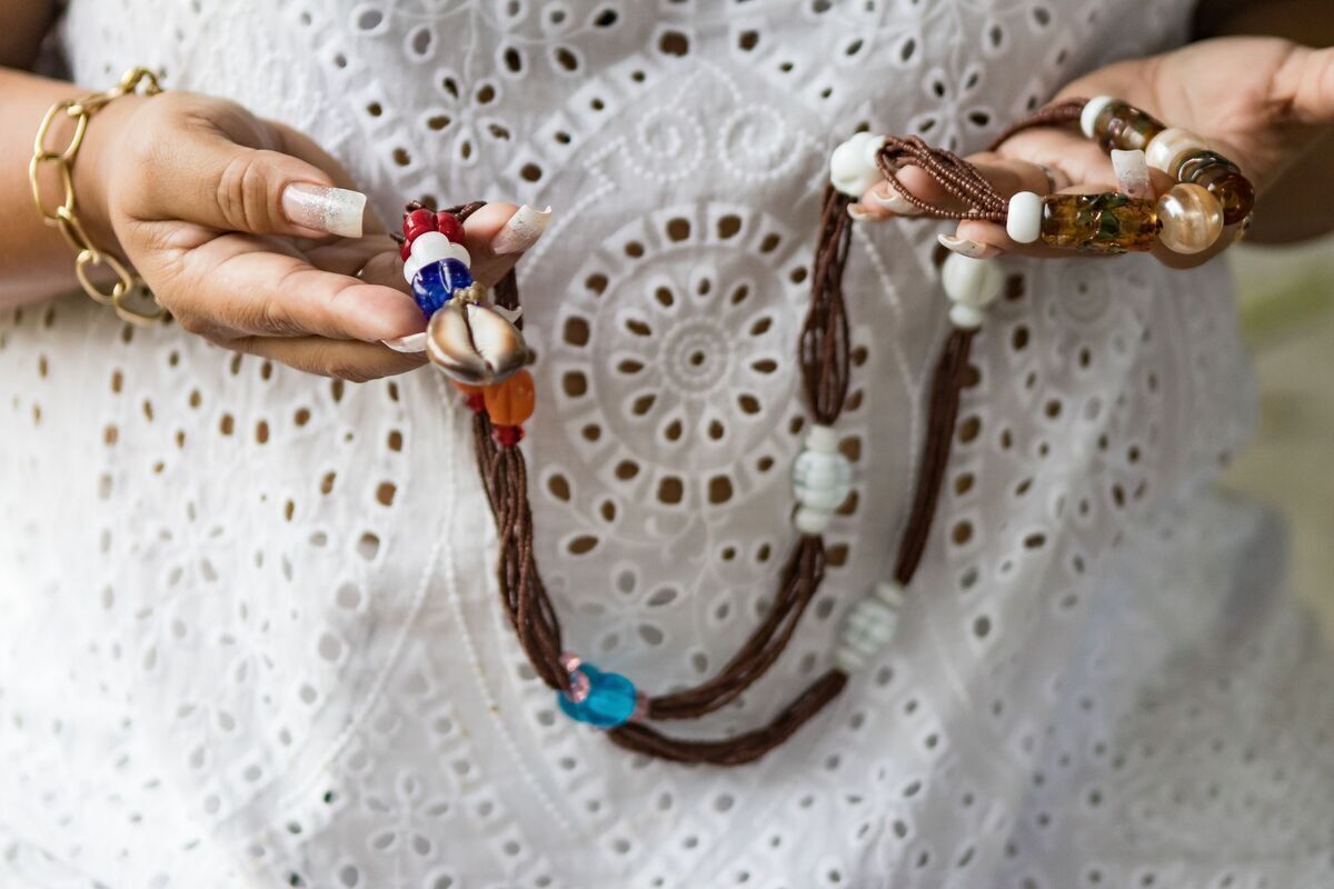 Pessoas trajadas de branco e usando cordões da Umbanda. 