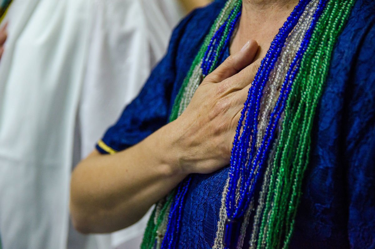 Homem com a mão no peito orando em um culto da Umbanda.