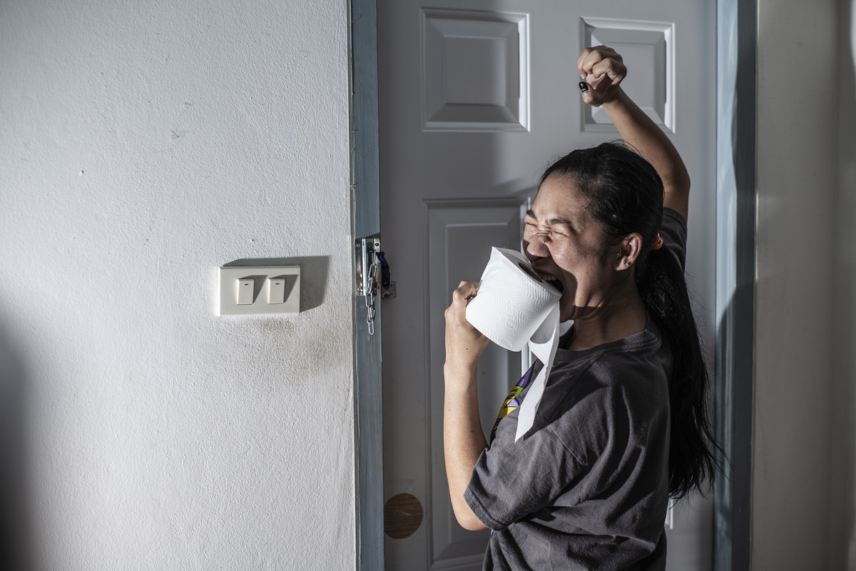 Mulher com papel higiênico na mão querendo usar o banheiro