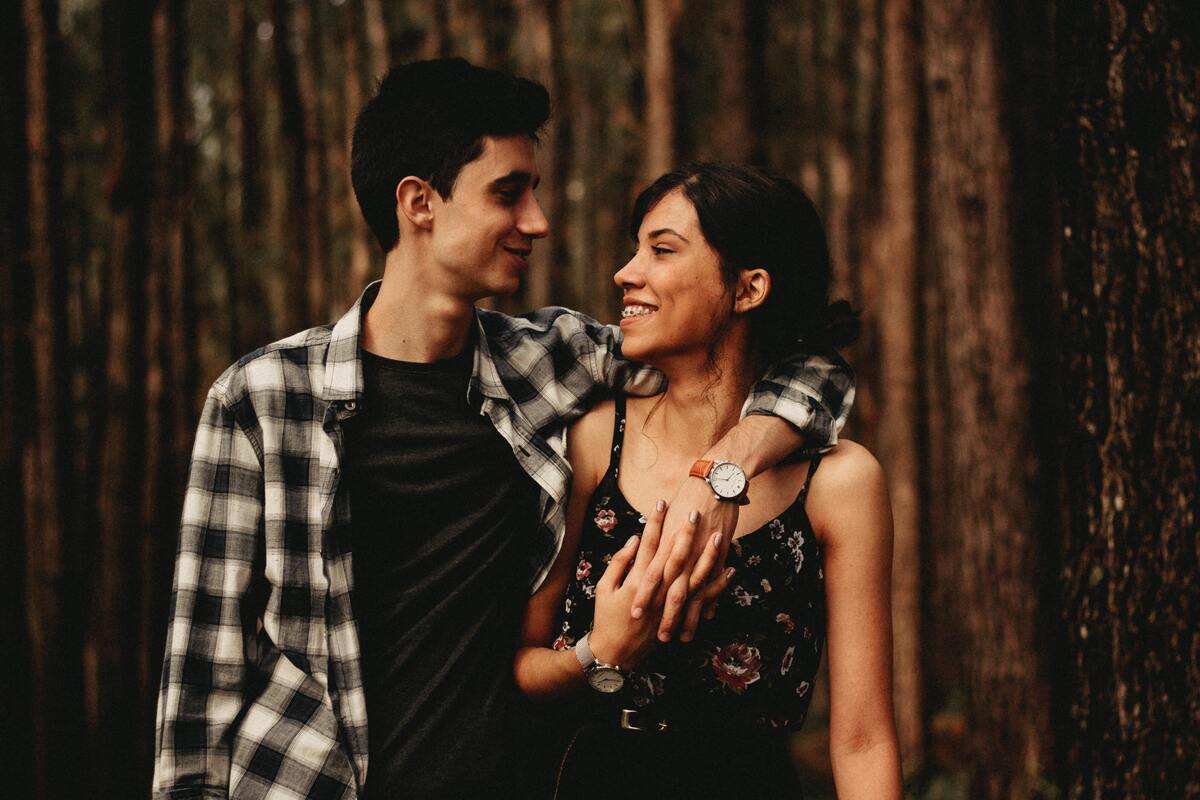 Casal abraçado se encarando.