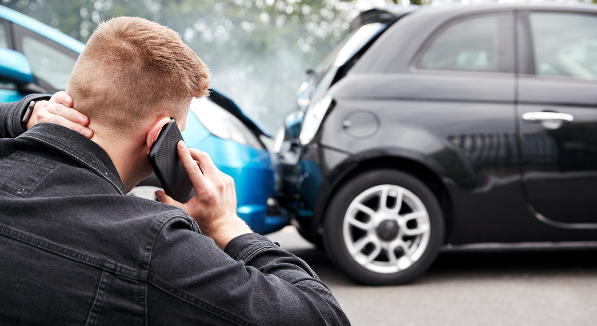 Homem vendo um acidente entre carros.