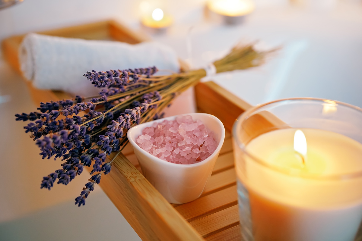 Itens para banho de limpeza e energização como toalha, vela, lavanda e cristais.