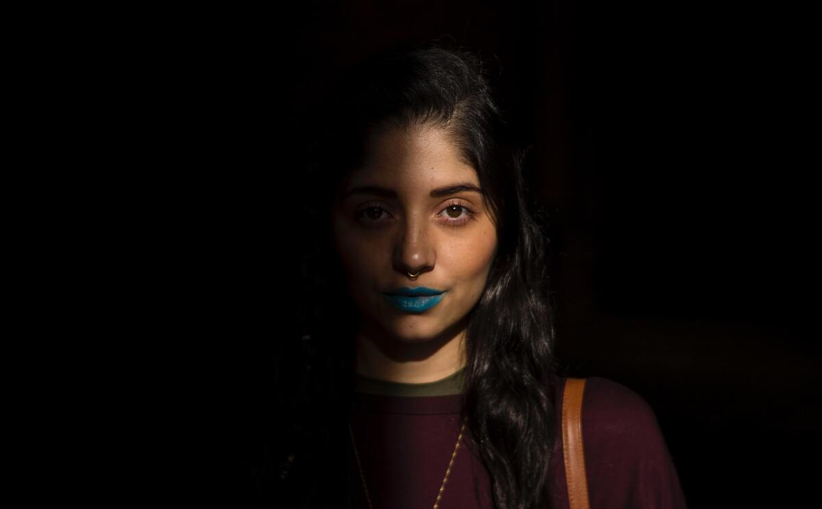 Mulher usando batom azul.