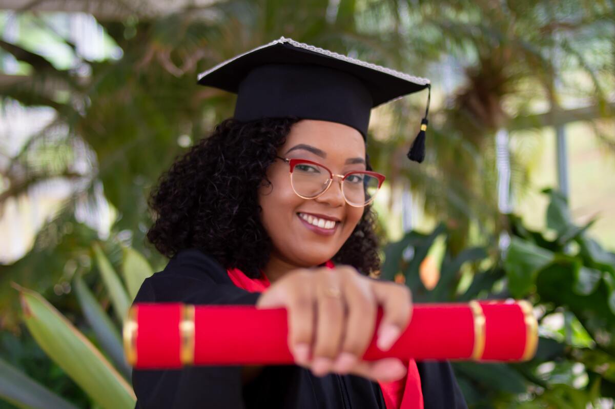 Mulher segurando diploma.