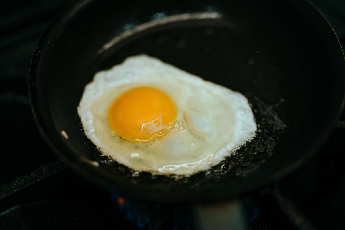 Ovo frito dentro de uma frigideira. 