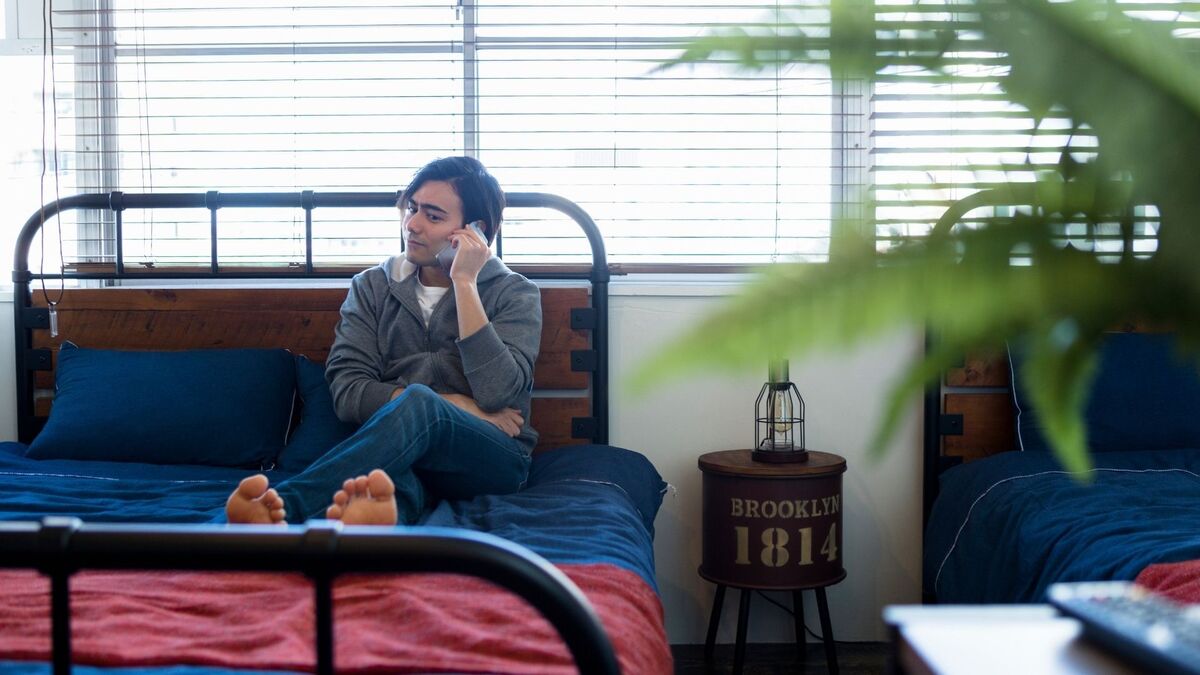 Homem ligando para alguém na cama.