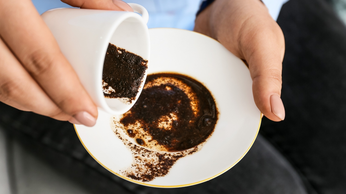 Mulher despejando borra de café no pires.