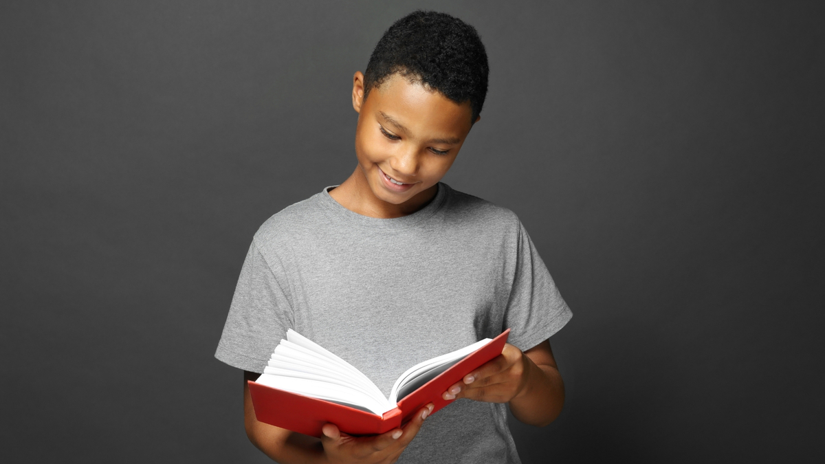 Menino lendo um livro.