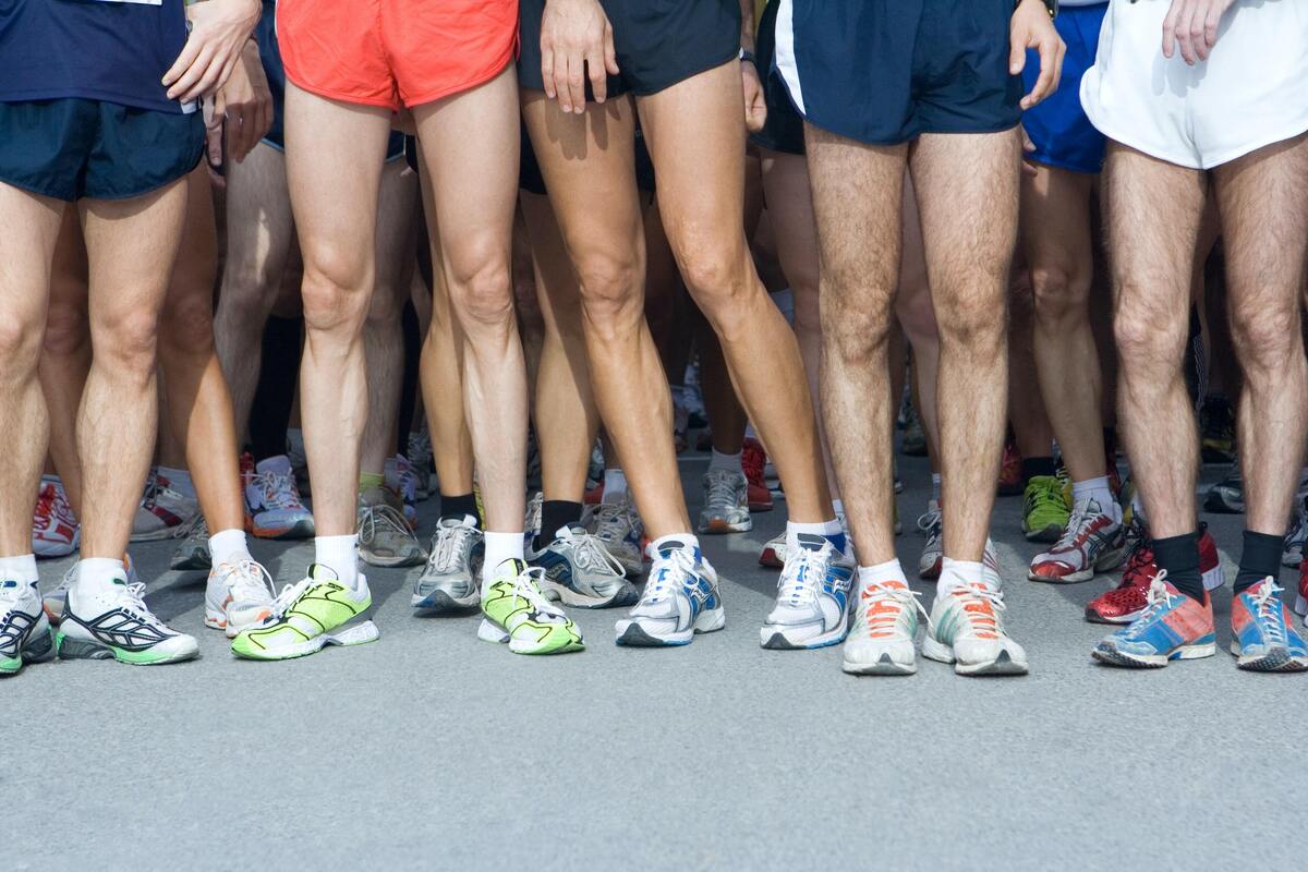 Penas de várias pessoas vestidas para uma corrida.