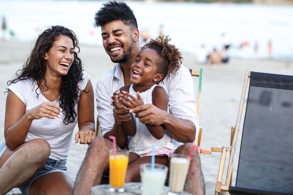 Mãe, pai e filha na praia.