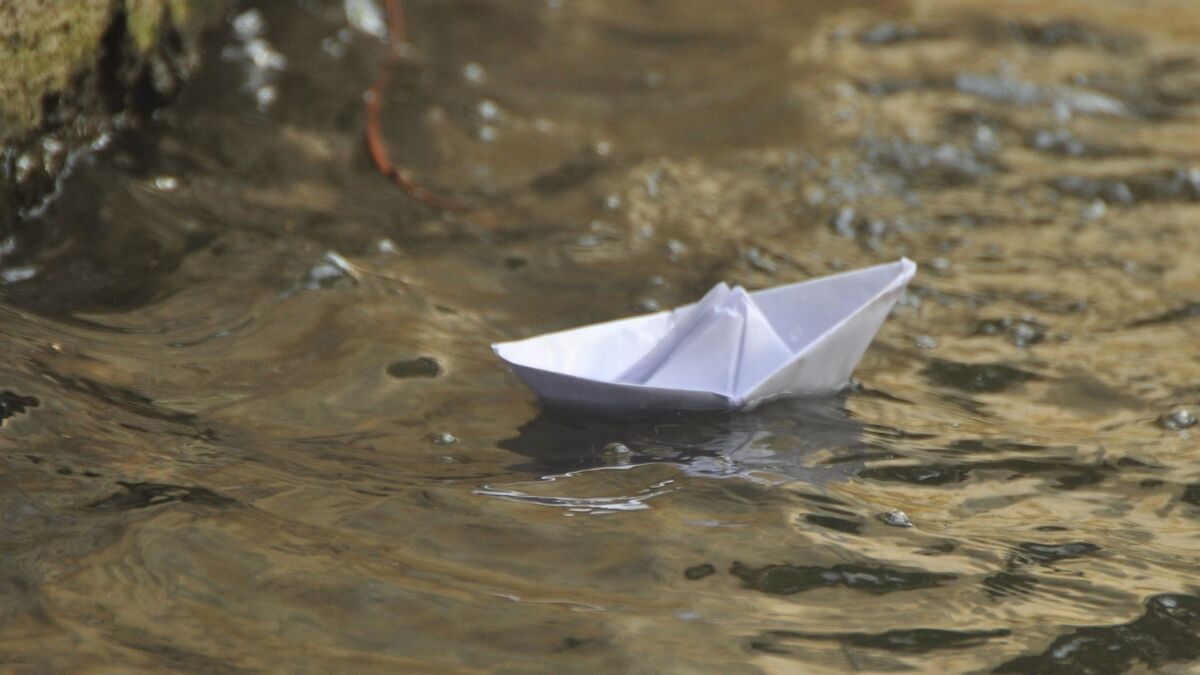 Barquinho de papel na água.