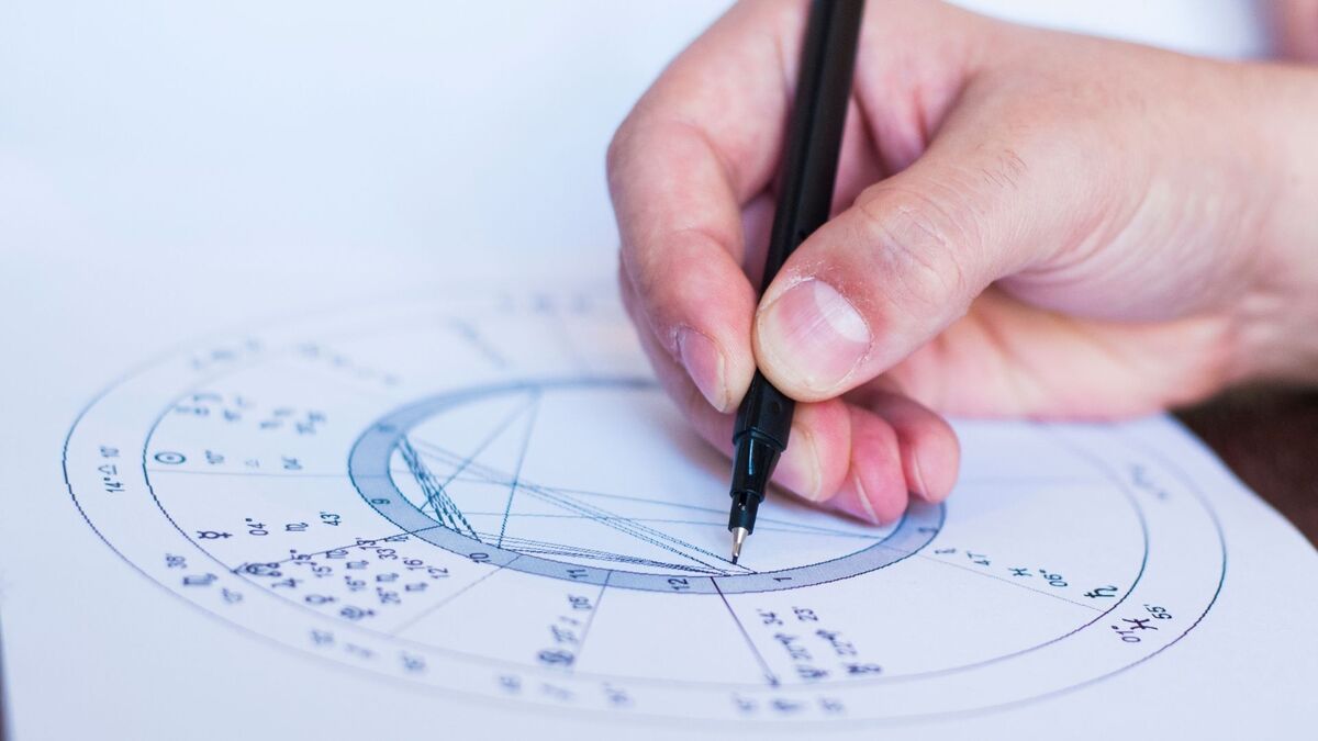 Mão fazendo um mapa astral.