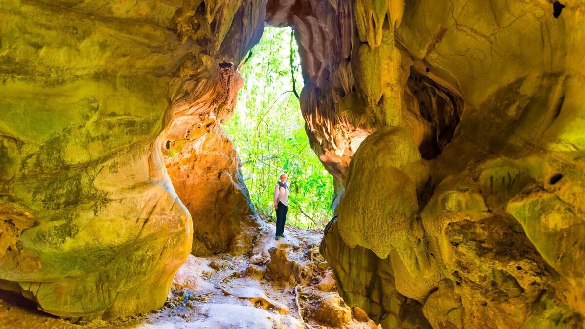 Pessoa na entrada de uma caverna.