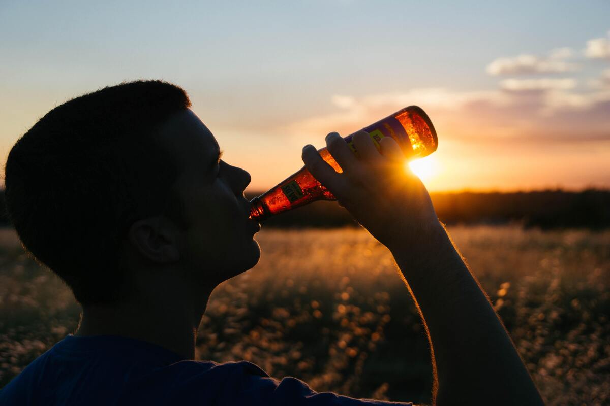 Silhueta de um homem bebendo cerveja.