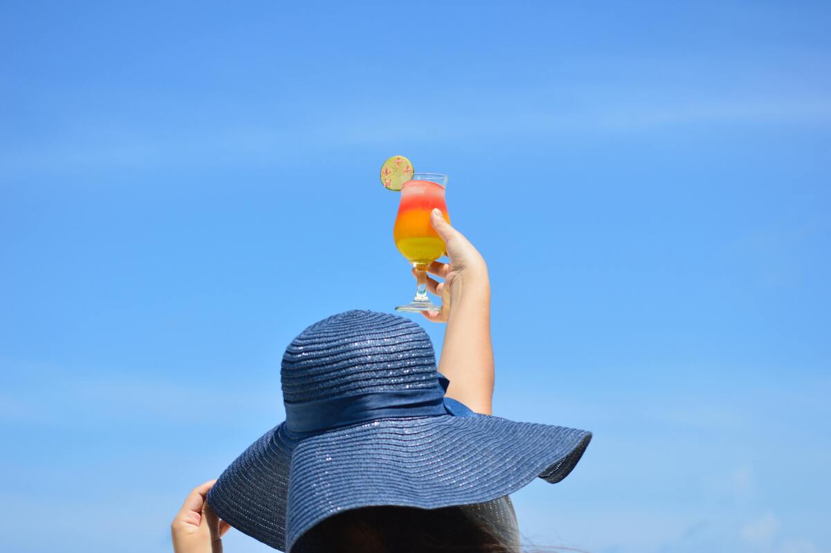 Mulher colocando o drink para o alto.