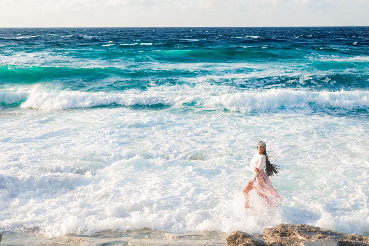 Mulher andando na beira do mar. 