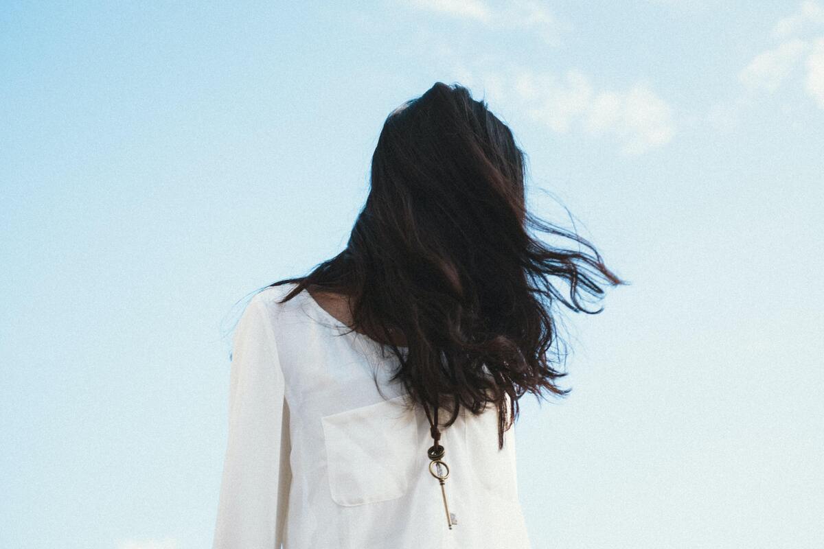 Mulher com o cabelo cobrindo o rosto.